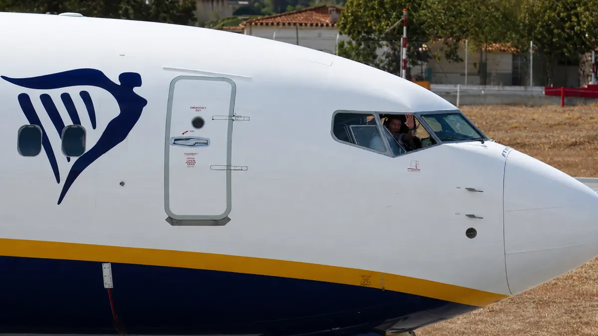 Pilot winkt aus dem Cockpitfenster einer Boeing 737 von Ryanair