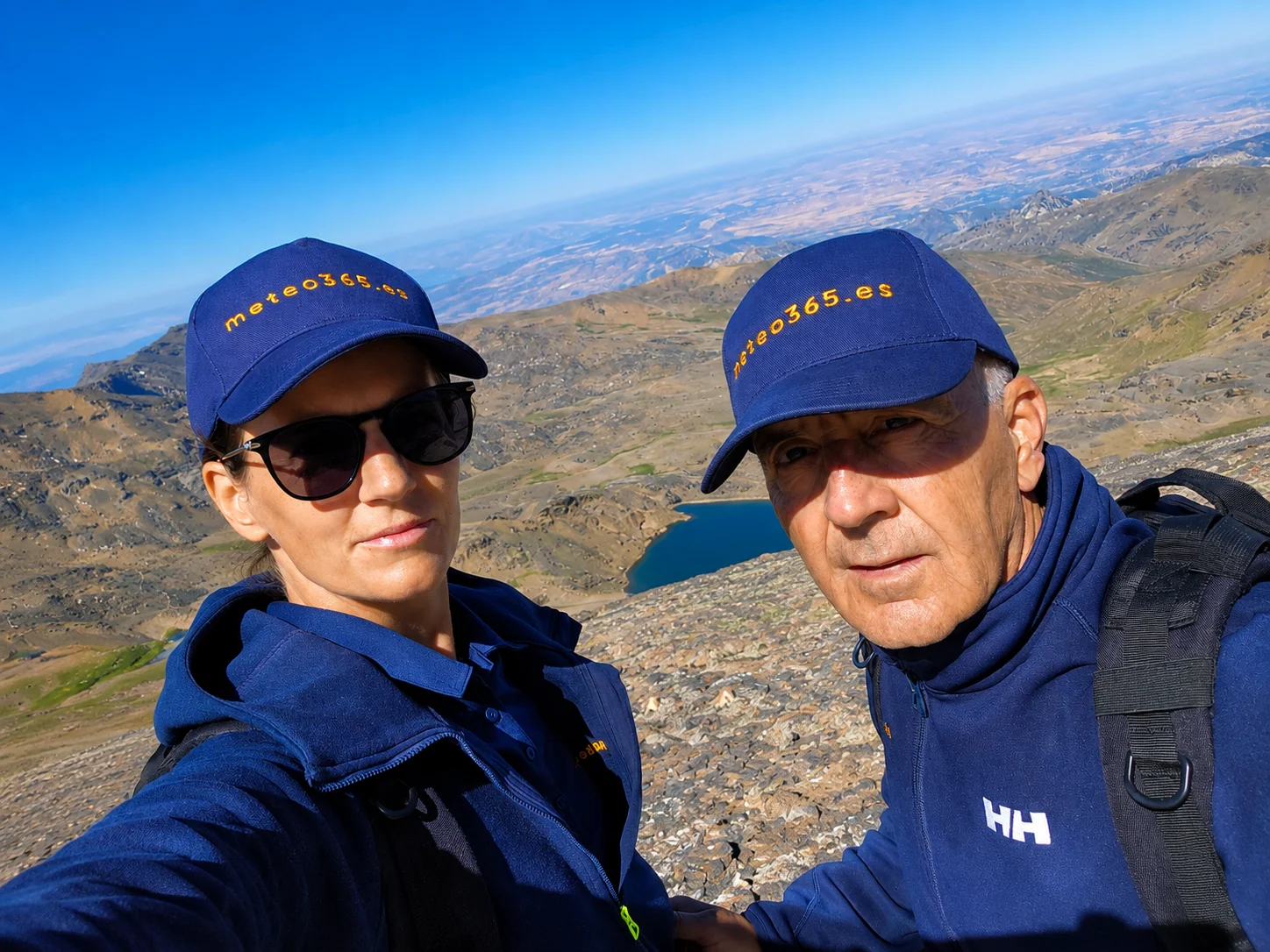 Maren and Thomas on a summit wearing meteo365.es caps